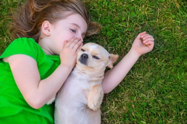 girl whispering in a dogs ear